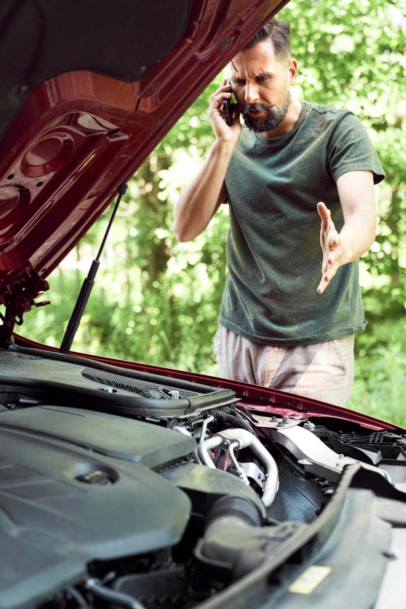 Junger Mann prüft Getriebeschaden bei Schrottauto Ankauf Walsrode